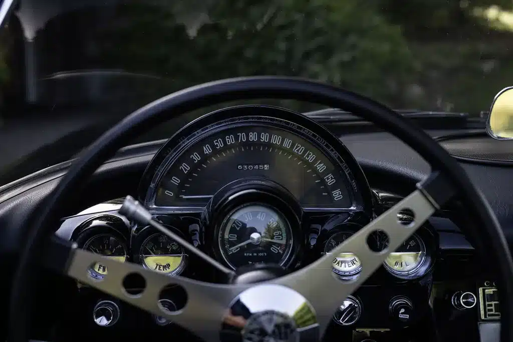 Blick auf das originale Armaturenbrett und Lenkrad einer schwarzen Chevrolet Corvette C1 Cabriolet von 1961.