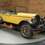 Chrysler Series G-70 Phaeton von 1926 mit gelber und schwarzer Lackierung, Holzspeichenrädern und offenem Verdeck, frontal seitlich fotografiert.