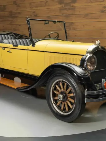 Chrysler Series G-70 Phaeton von 1926 mit gelber und schwarzer Lackierung, Holzspeichenrädern und offenem Verdeck, frontal seitlich fotografiert.