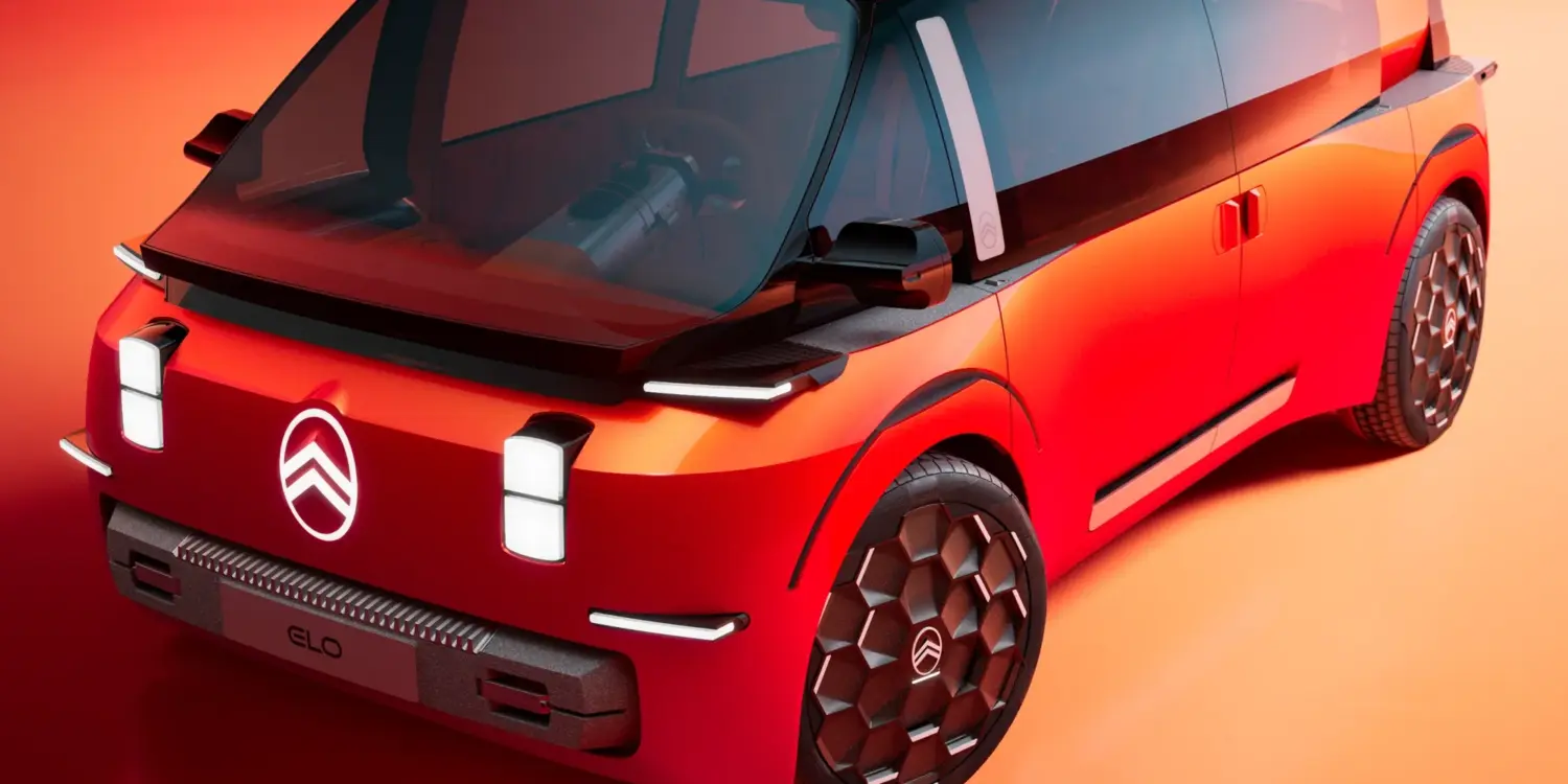 Das Citroën ELO Concept Elektroauto in markantem Rot, aufgenommen vor orangem Hintergrund, mit futuristischem Design und großen Glasflächen.