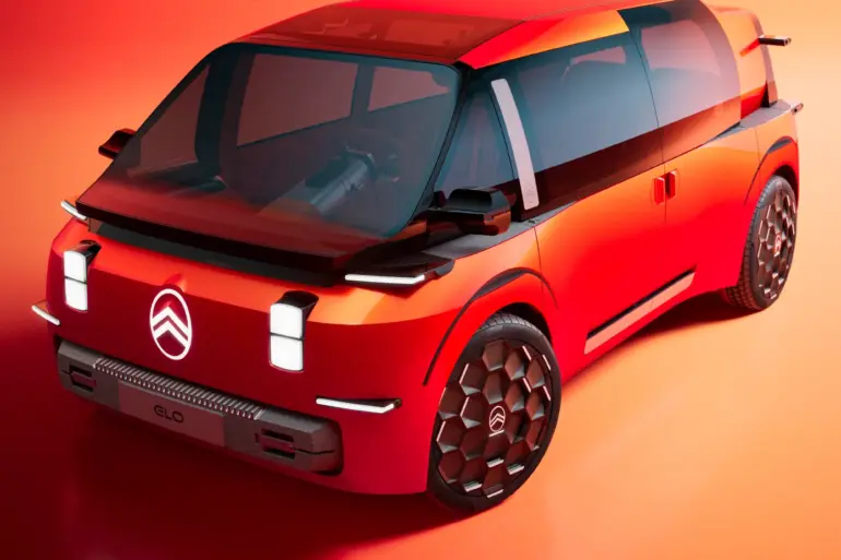 Das Citroën ELO Concept Elektroauto in markantem Rot, aufgenommen vor orangem Hintergrund, mit futuristischem Design und großen Glasflächen.