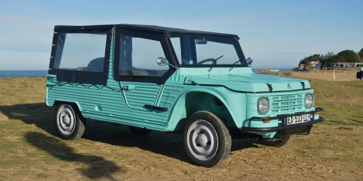 Citroën Méhari von 1978 in Türkisgrün, restauriert, Cabrioverdeck, am Strand geparkt.