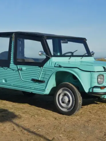 Citroën Méhari von 1978 in Türkisgrün, restauriert, Cabrioverdeck, am Strand geparkt.