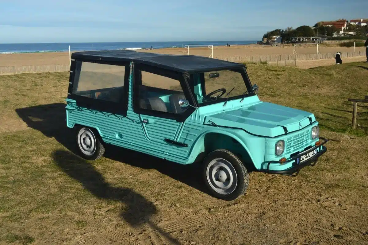Restaurierter Citroën Méhari von 1978 in Grün mit schwarzem Verdeck am Sandstrand