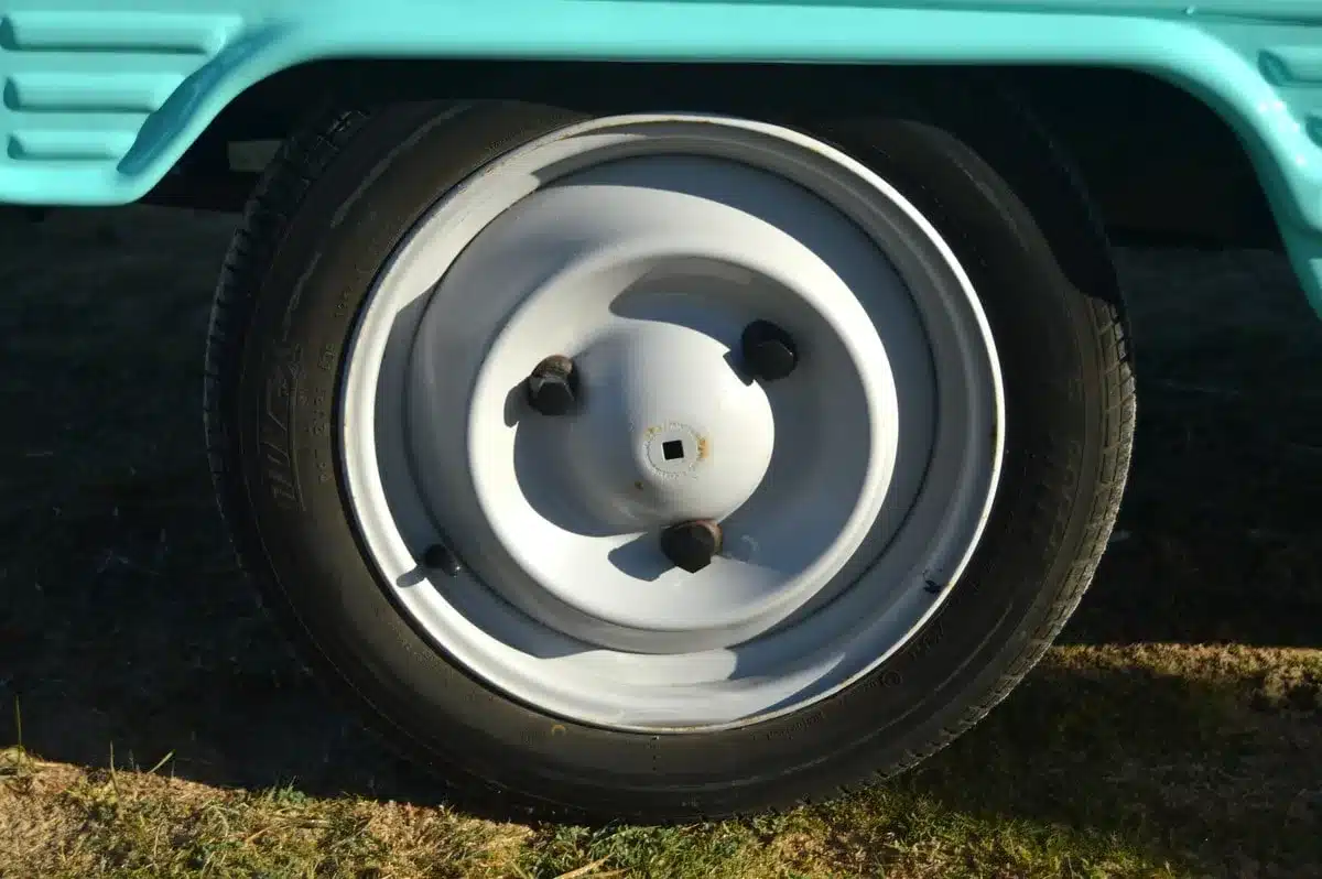 Detailaufnahme des Vorderrads eines Citroën Méhari mit türkisfarbener Kunststoffkarosserie