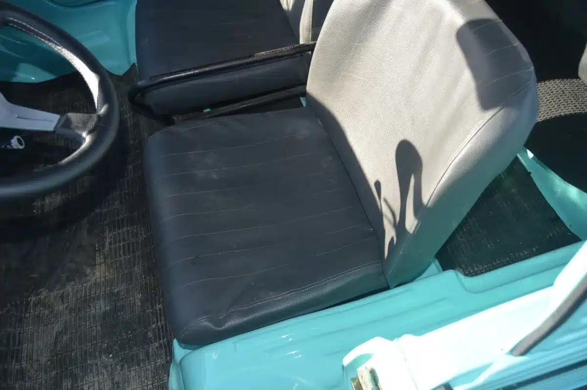 Der Innenraum eines Citroën Méhari von 1978 mit schwarzen Sitzen und Lenkrad