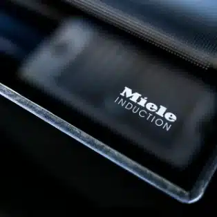Miele Induktionskochfeld in Nahaufnahme, Detailansicht der Kante und Logo