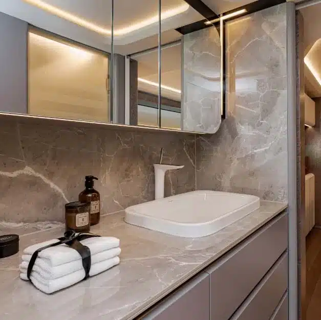 Elegantes Badezimmer mit Waschtisch, Spiegel und Marmordekor im Dembell Serenity Luxus-Reisemobil