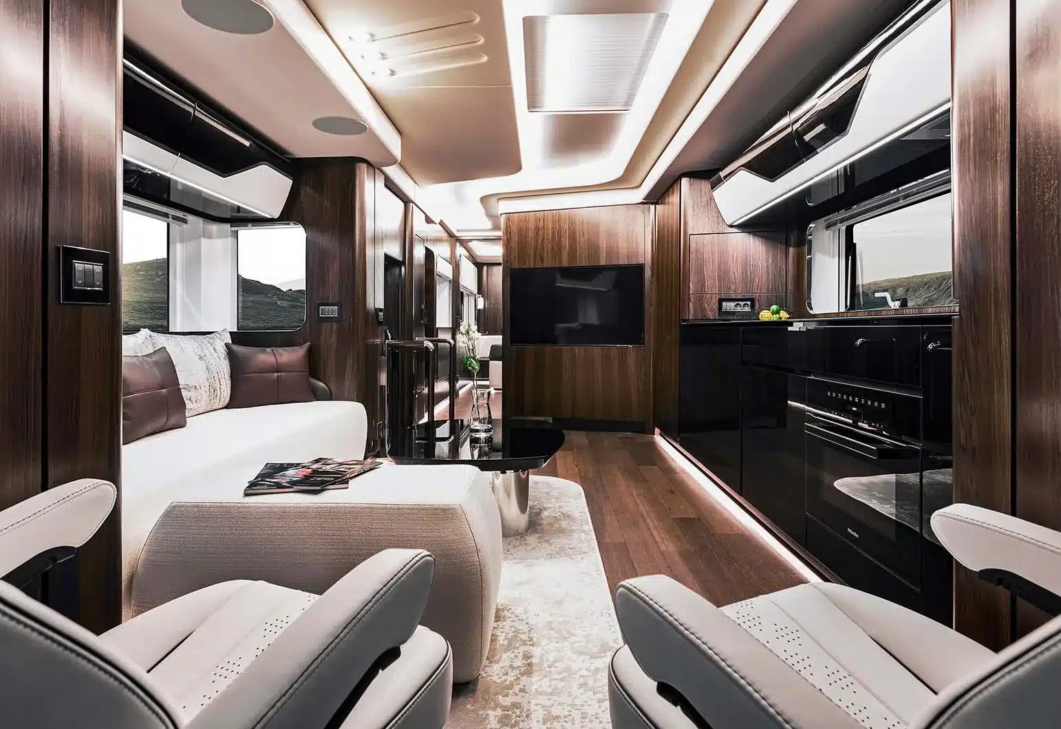 Hochwertig gestalteter Innenraum eines Reisemobils mit edlen Holzverkleidungen, komfortablen Sitzen, moderner Küche und Wohnbereich.