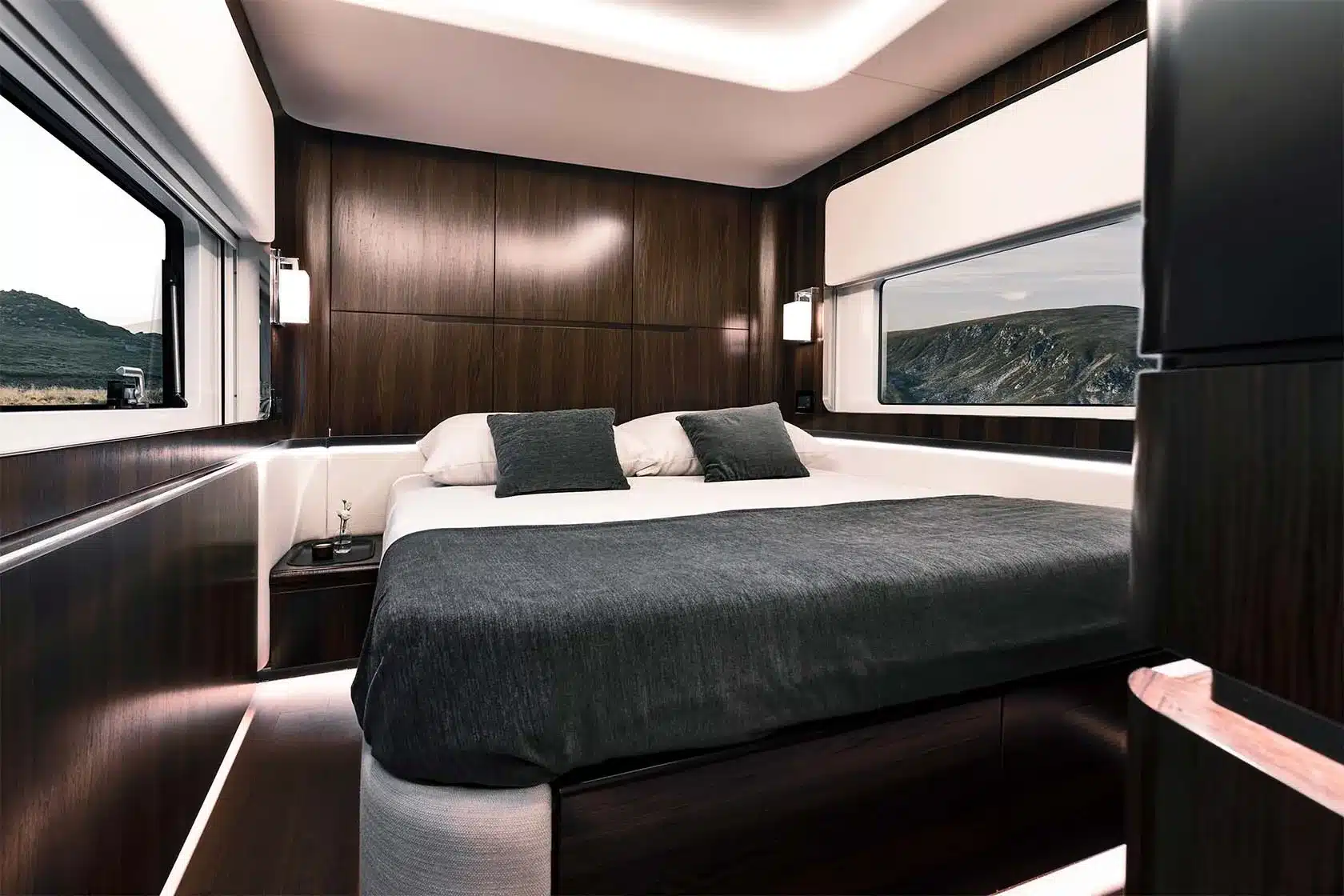 Modernes Schlafzimmer mit großem Bett und edlem Holzdekor im Dembell Smart-Garage Wohnmobil