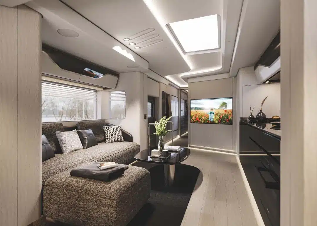 Luxuriöser Wohnraum im Dembell Smart-Garage Reisemobil mit großer Couch, Flachbildfernseher und eleganter Ausstattung.