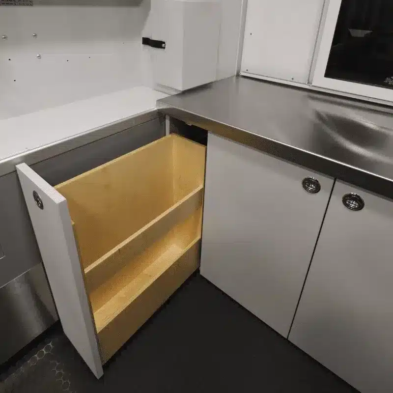 Offener Auszugsschrank und Edelstahl-Arbeitsfläche im Mobile Vet von Vancini Conversions.