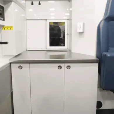 Edelstahl-Arbeitsfläche und maßgefertigte Schränke im Inneren der mobilen Tierarztpraxis auf Mercedes Sprinter Basis