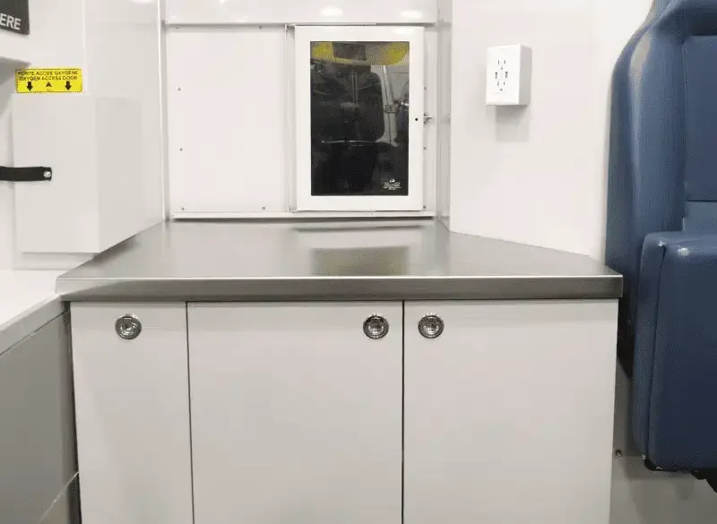 Edelstahl-Arbeitsfläche und maßgefertigte Schränke im Inneren der mobilen Tierarztpraxis auf Mercedes Sprinter Basis