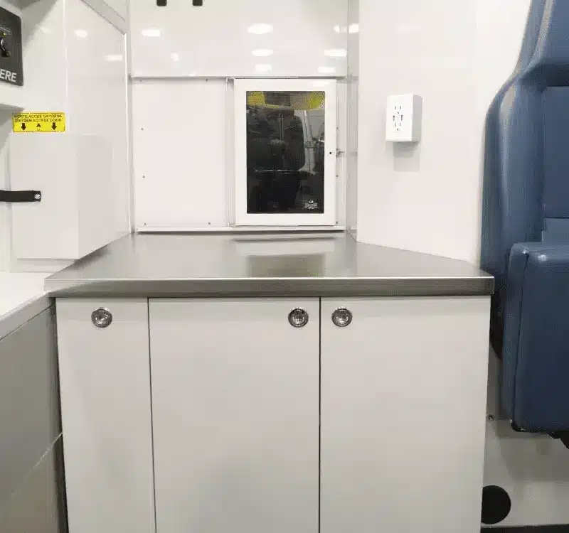 Edelstahl-Arbeitsfläche und maßgefertigte Schränke im Inneren der mobilen Tierarztpraxis auf Mercedes Sprinter Basis
