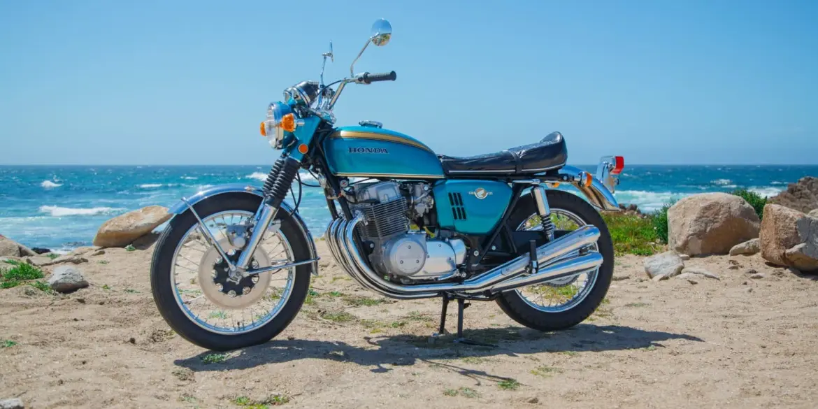 Honda CB750 Prototyp von 1968 mit blauem Tank, stehend am Strand vor dem Meer