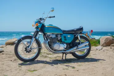 Honda CB750 Prototyp von 1968 mit blauem Tank, stehend am Strand vor dem Meer
