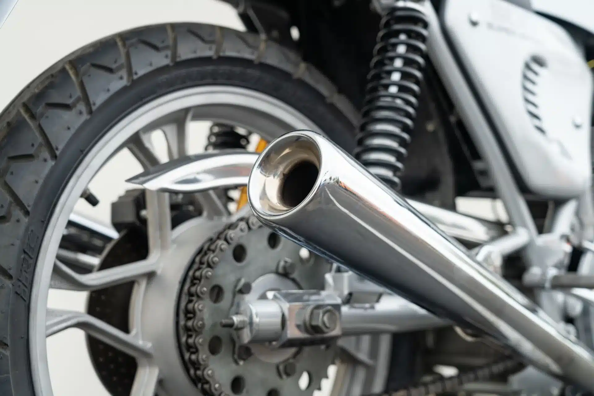 Auspuff, Hinterrad und Kette einer Ducati 900 Super Sport 1975 in Nahaufnahme.