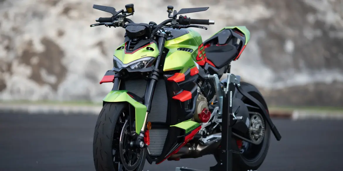 Ducati Streetfighter V4 Lamborghini in Citrea Green mit Dac Orange und schwarzen Akzenten auf einer Ausstellungsfläche.