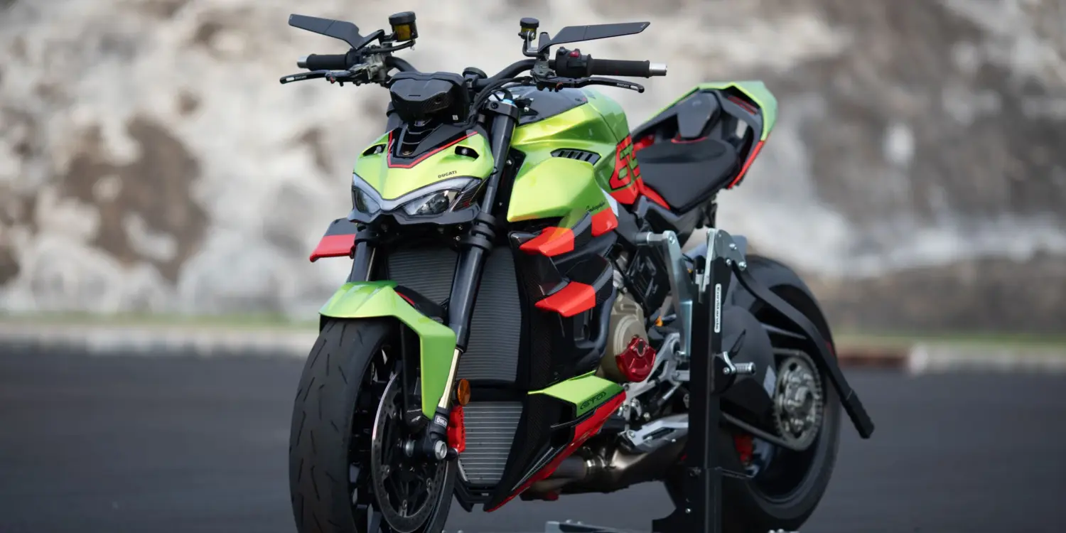 Ducati Streetfighter V4 Lamborghini in Citrea Green mit Dac Orange und schwarzen Akzenten auf einer Ausstellungsfläche.