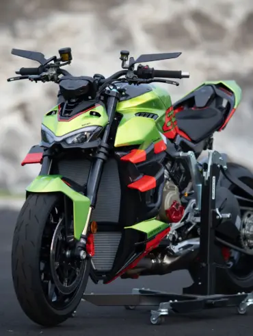 Ducati Streetfighter V4 Lamborghini in Citrea Green mit Dac Orange und schwarzen Akzenten auf einer Ausstellungsfläche.