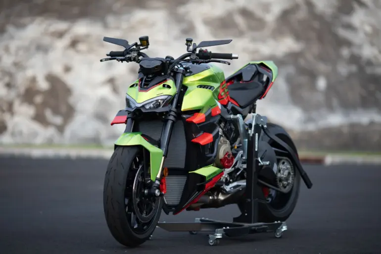 Ducati Streetfighter V4 Lamborghini in Citrea Green mit Dac Orange und schwarzen Akzenten auf einer Ausstellungsfläche.