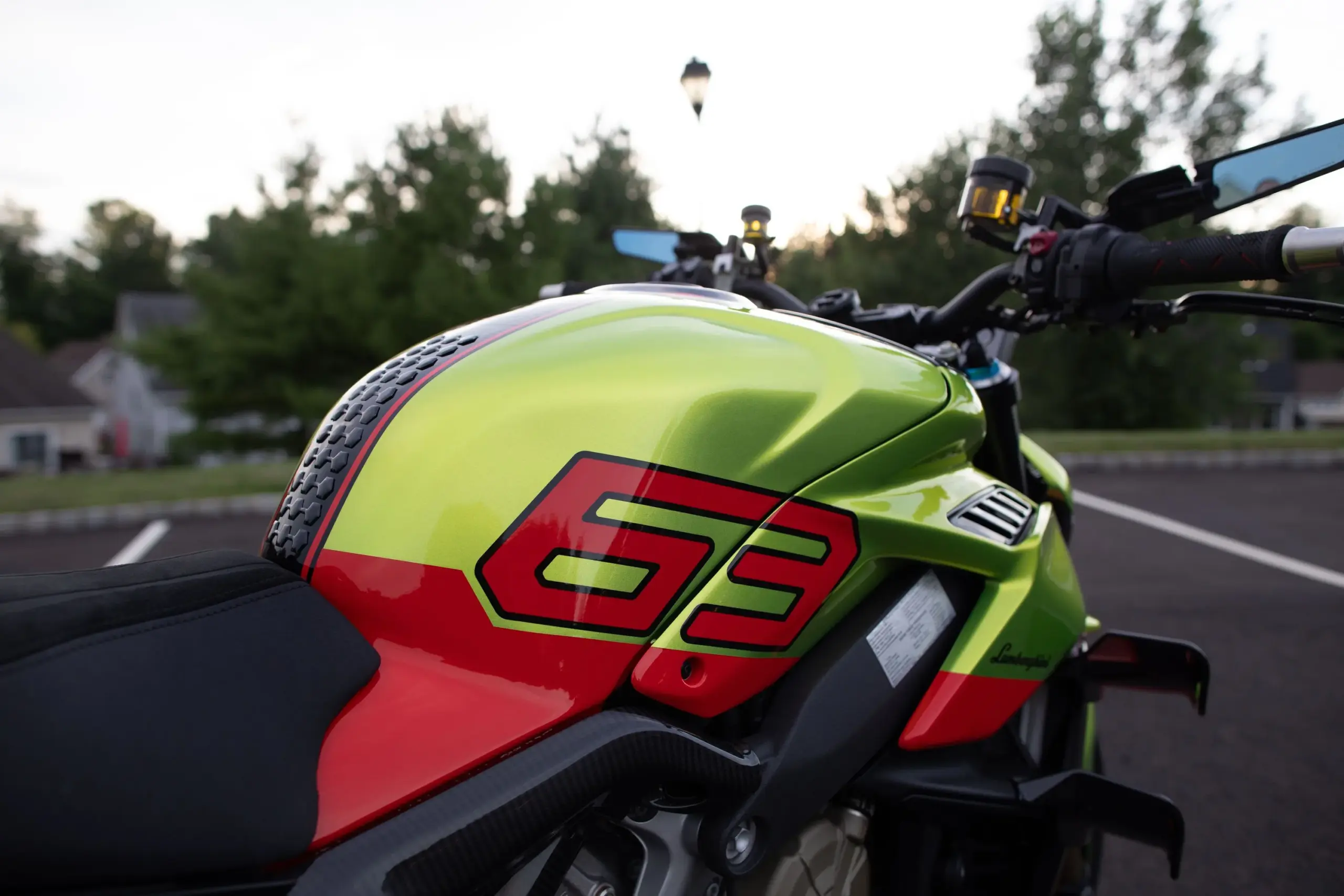 Nahaufnahme des Tanks einer Ducati Streetfighter V4 Lamborghini in Citrea Green mit roter '63'-Grafik und schwarzen Akzenten.