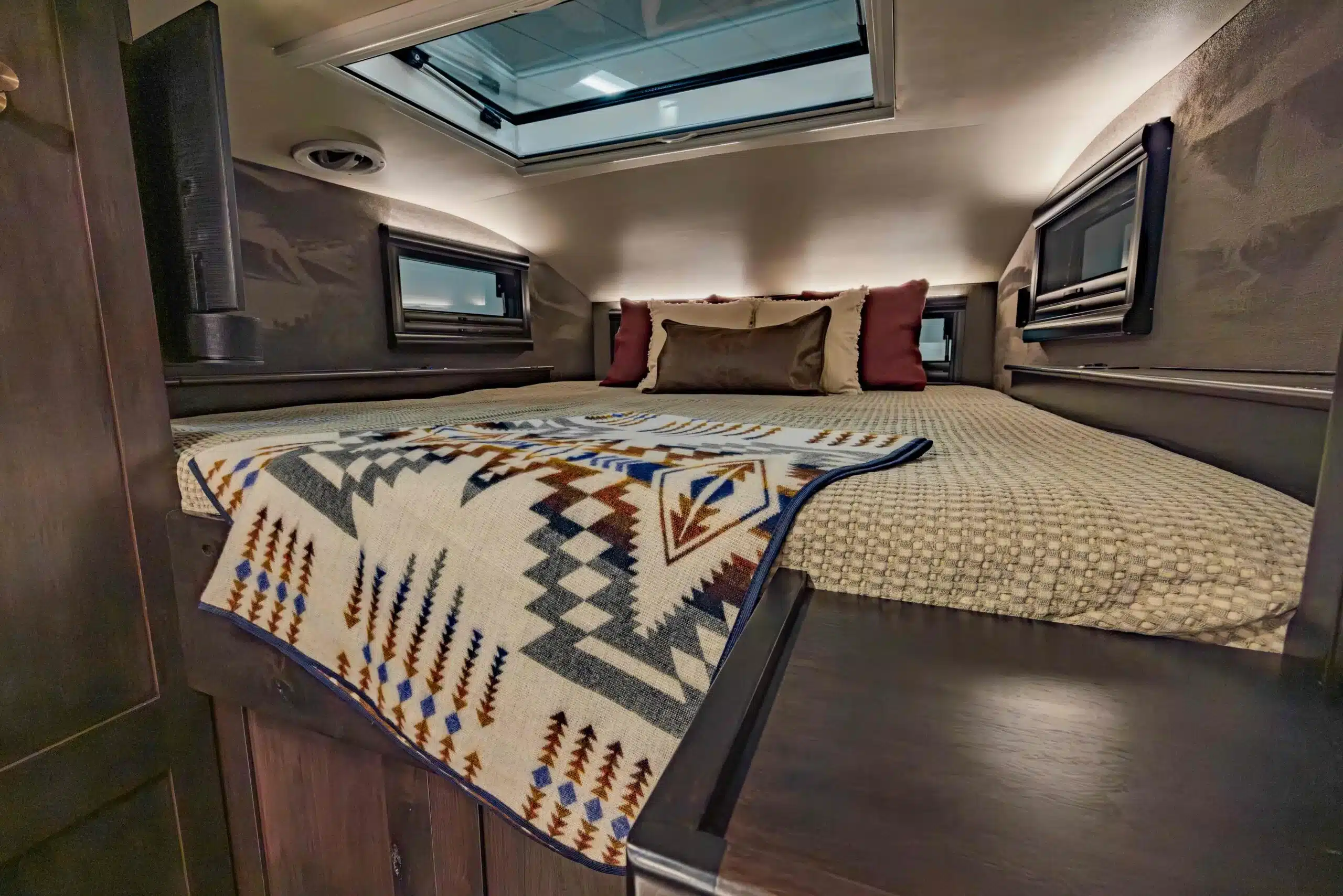 Hochwertig ausgestatteter Schlafbereich mit Oberlicht und stilvollen Kissen im EarthRoamer LTX Explore Expeditionsmobil