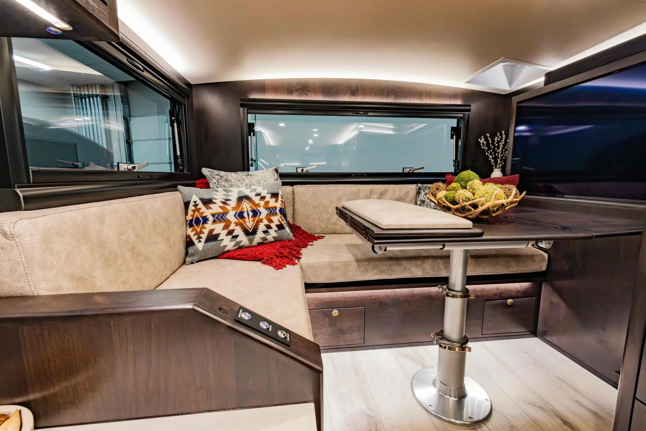 Sitzecke mit Tisch, Kissen und Dekoration im Innenraum eines EarthRoamer LTX Explore Expeditionsmobils