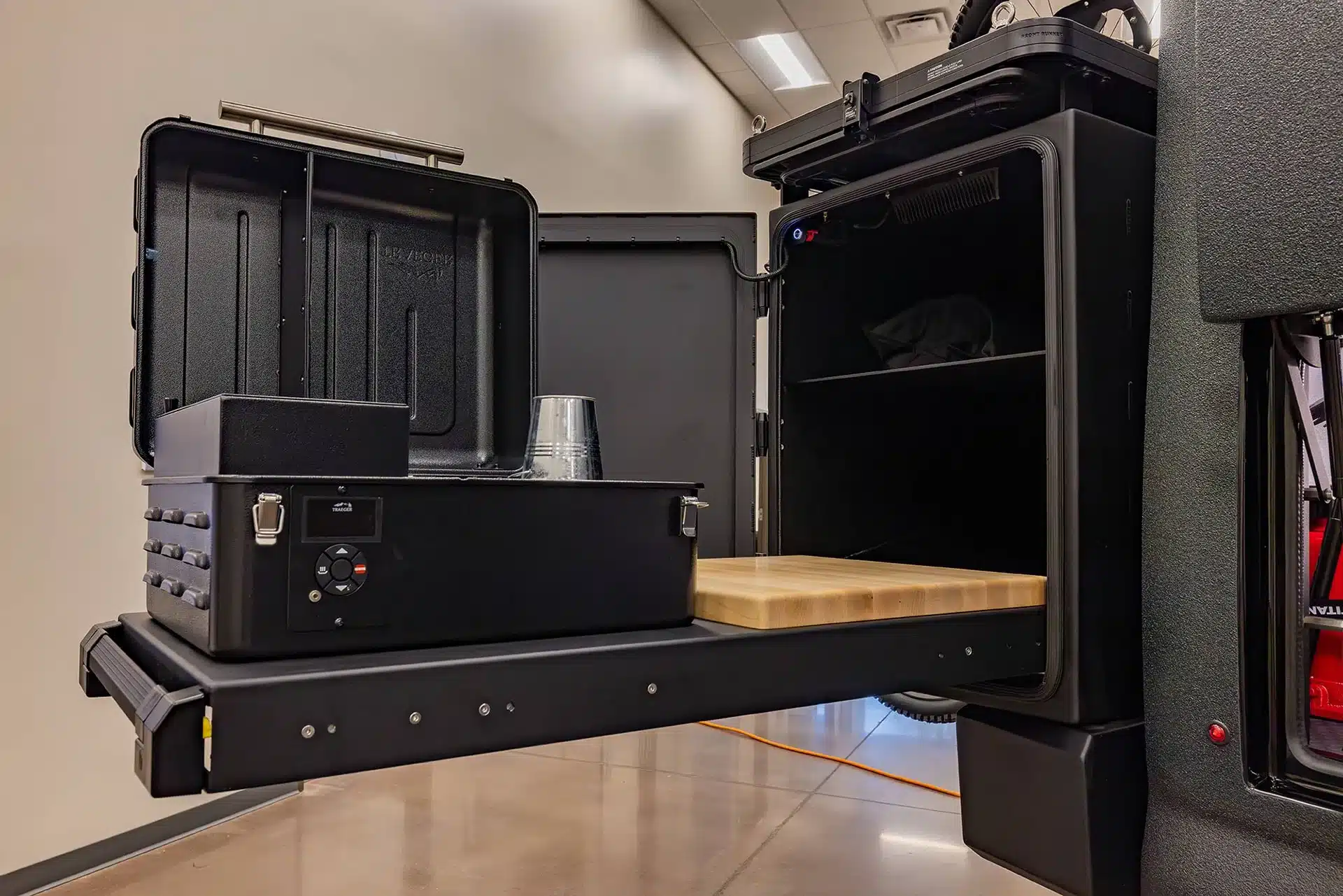 Ausziehbare Außenküche des EarthRoamer LTX Explore mit Kochmodul, Schneidebrett und Stauraum.