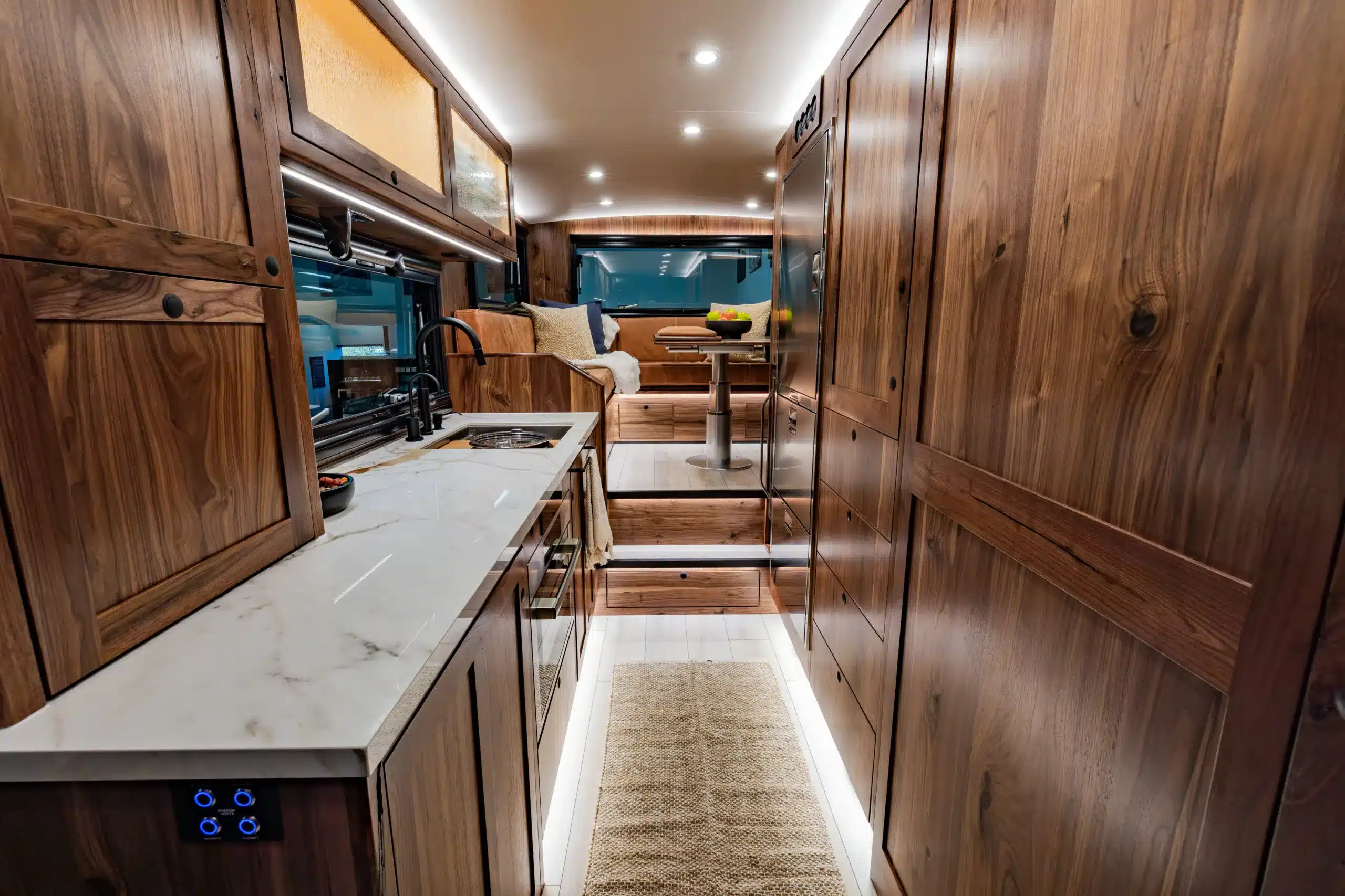Luxuriöser Innenraum eines EarthRoamer SX Explore Expeditionsmobils mit edlem Holzdekor, Küche und Sitzbereich.