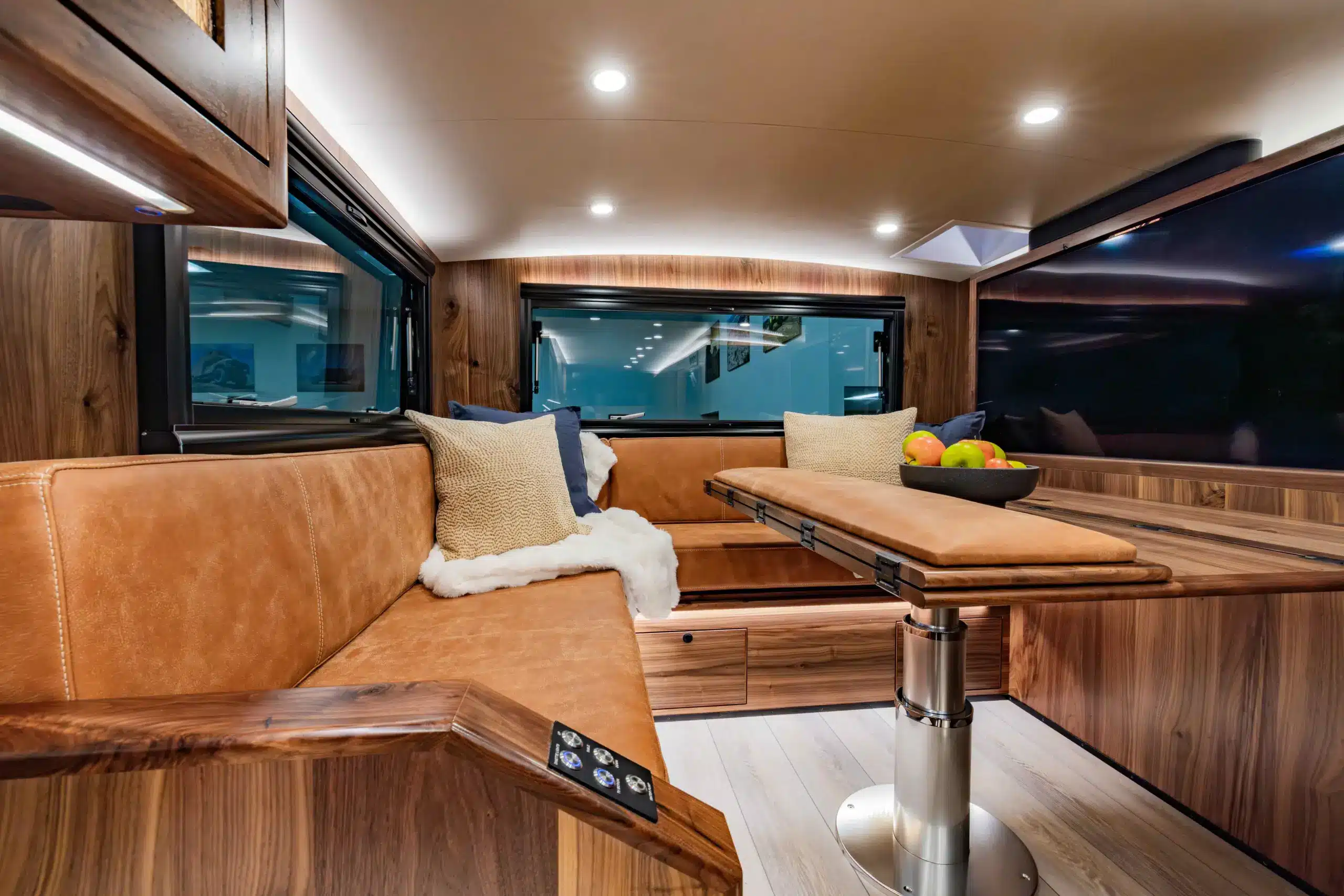 Sitz- und Wohnbereich mit edlen Materialien und großem Tisch im Expeditionsfahrzeug EarthRoamer SX Explore.