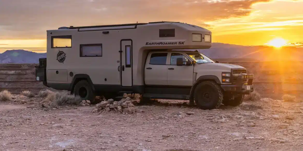 EarthRoamer SX Explore Expeditionsfahrzeug vor Sonnenuntergang in karger Landschaft.