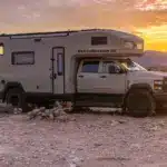 EarthRoamer SX Explore Expeditionsfahrzeug vor Sonnenuntergang in karger Landschaft.