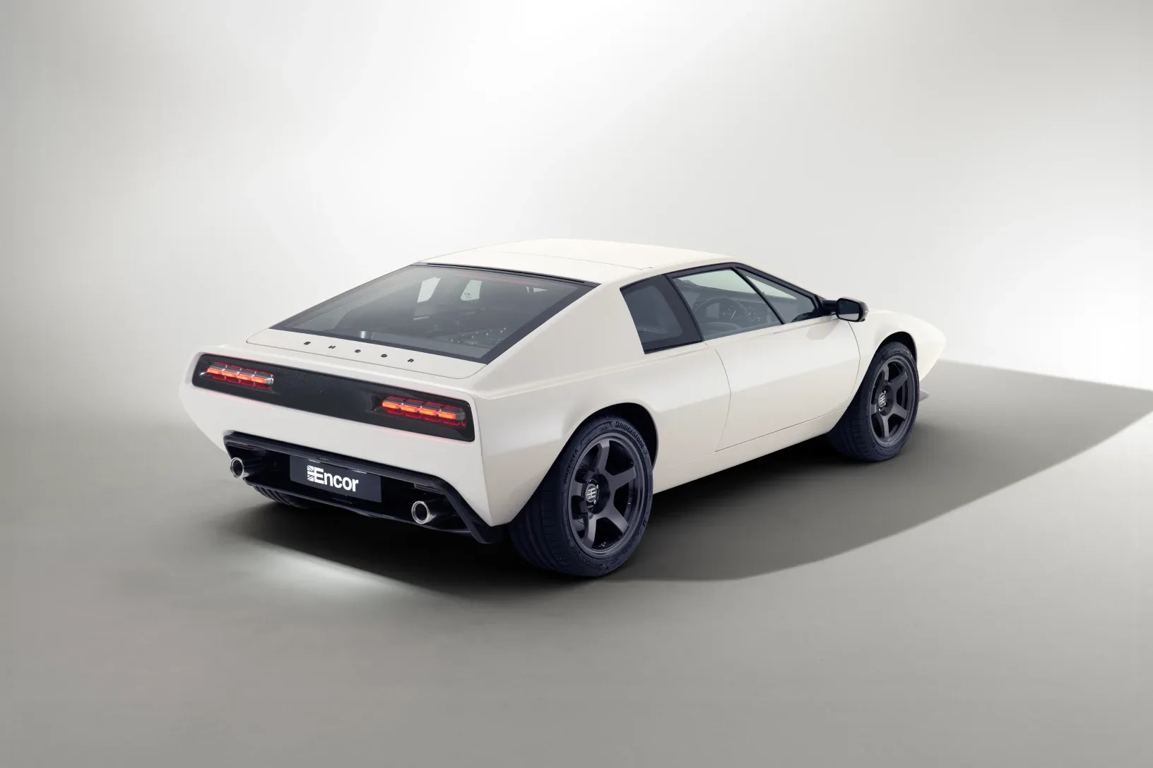 Der Encor Series 1 in Weiß, ein moderner Sportwagen auf Basis des Lotus Esprit S1, von schräg hinten fotografiert, im Fotostudio.
