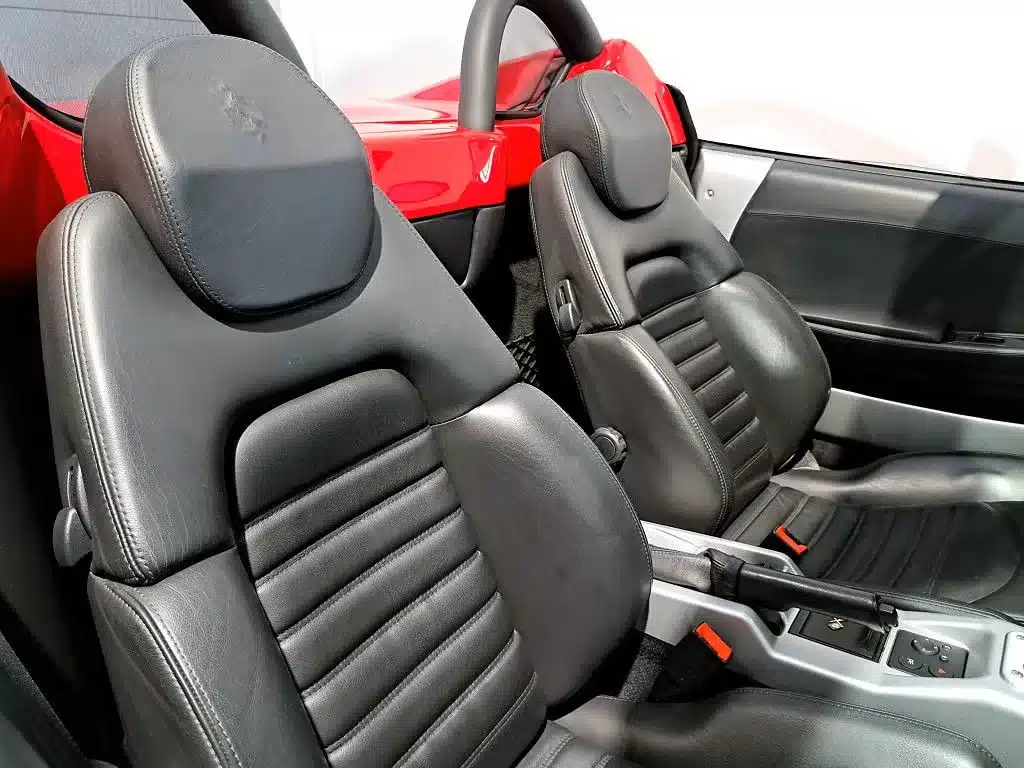 Schwarze Ledersitze im Innenraum eines Ferrari 360 Spider von 2002, gepflegter Zustand.