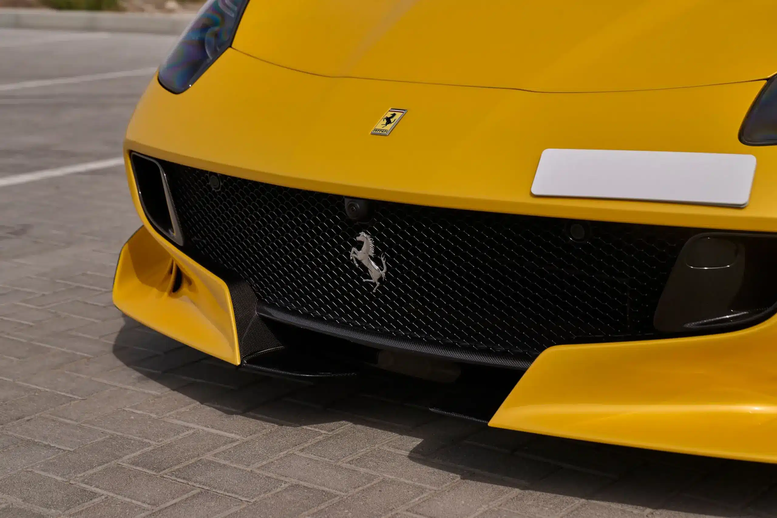 Frontansicht eines gelben Ferrari F12 TDF mit sichtbarem Ferrari-Logo und Carbon-Frontsplitter