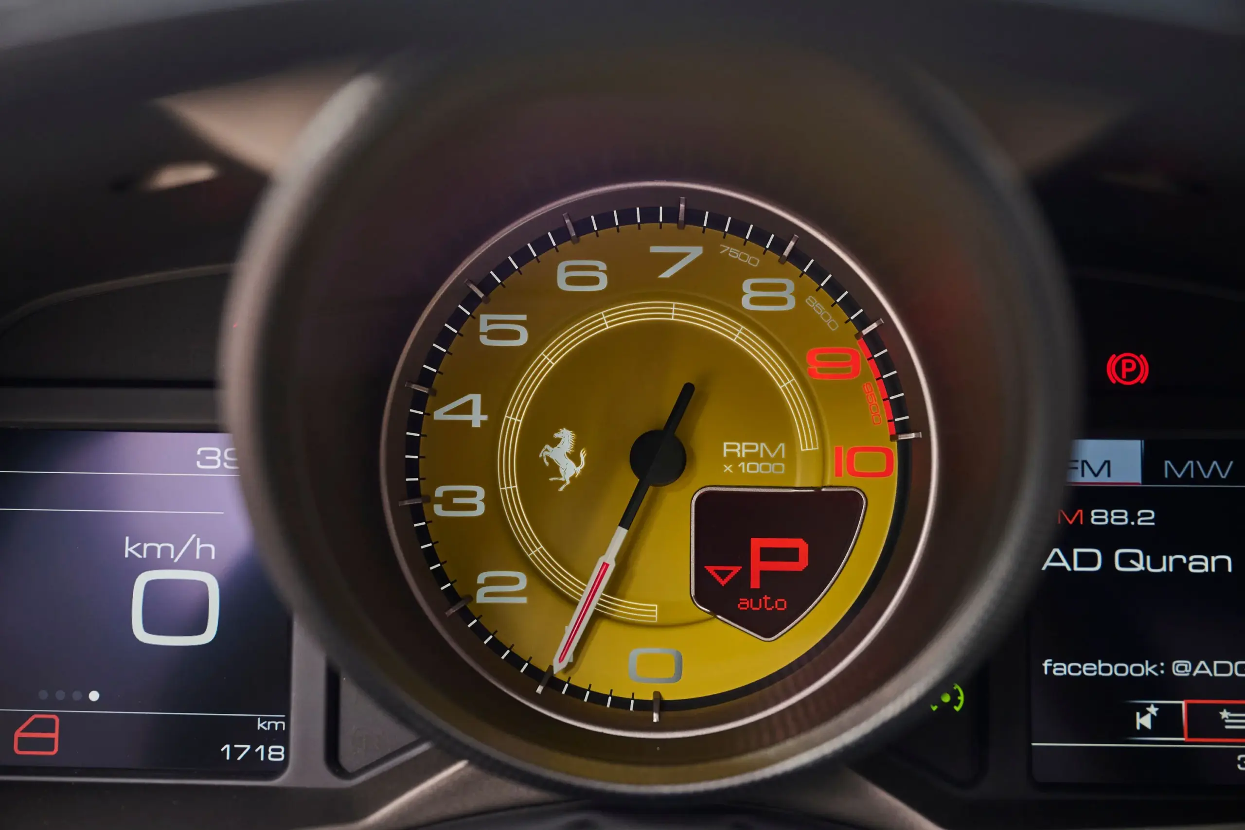 Gelber Drehzahlmesser im Cockpit eines Ferrari F12 TDF, flankiert von digitalen Anzeigen