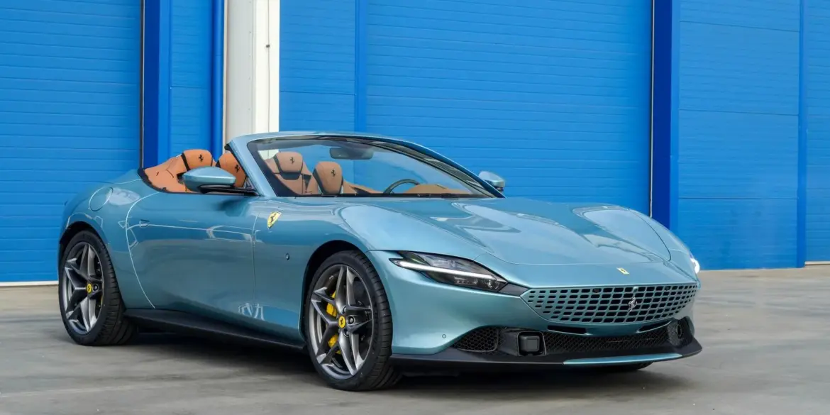 Ferrari Roma Spider 2025 in Celeste Trevi mit offenem Dach und braunem Lederinterieur, Seitenansicht.