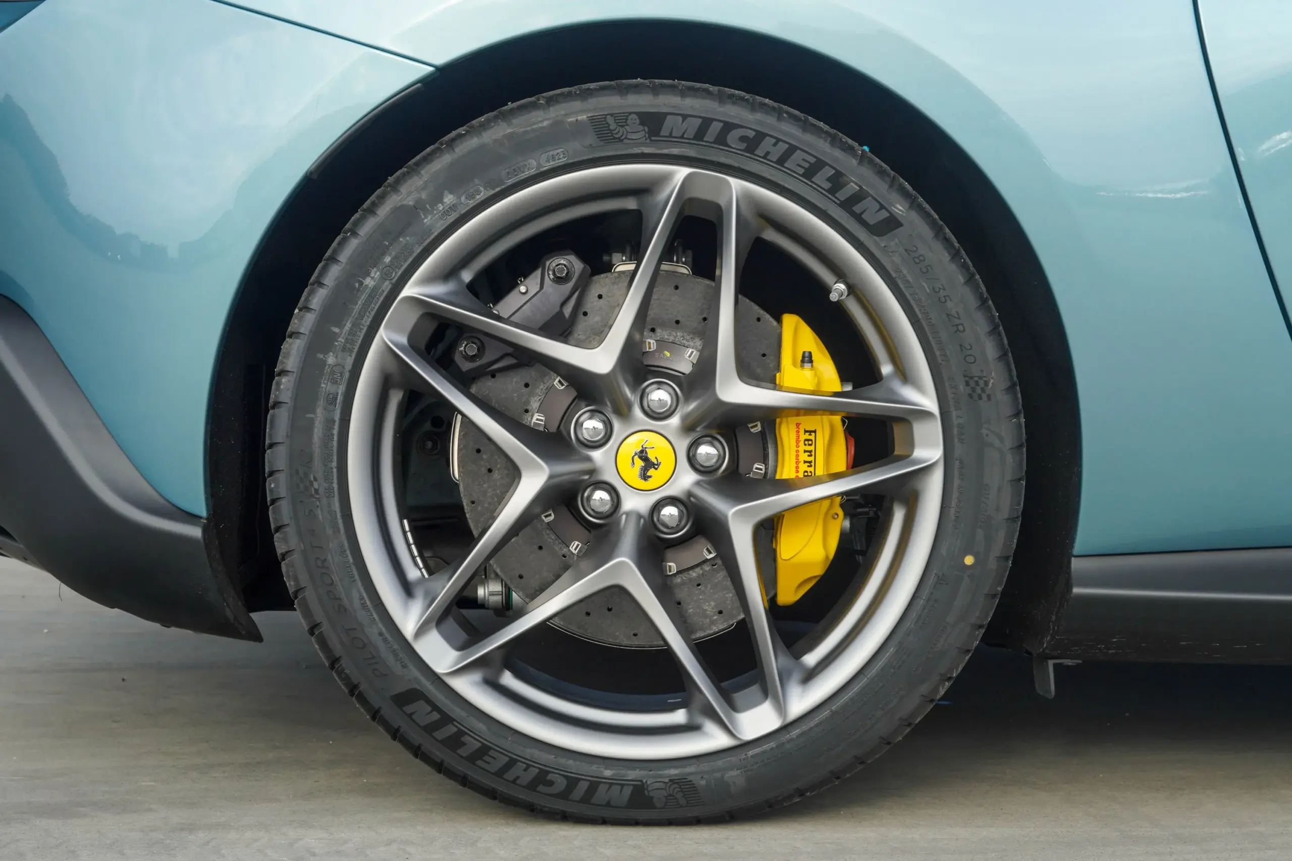 Nahaufnahme einer matten 20-Zoll-Felge mit Michelin Pilot Sport 4S Reifen und gelbem Ferrari-Bremssattel am Ferrari Roma Spider