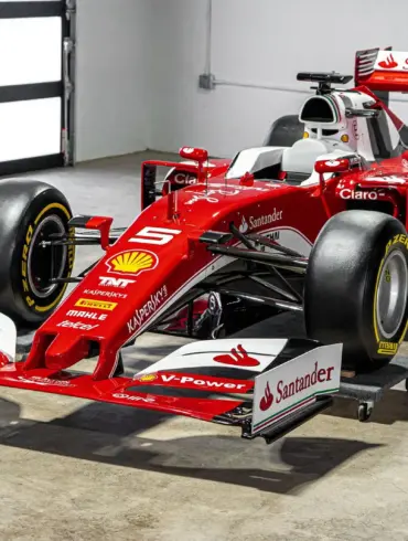 Lebensgroße Replika eines Ferrari SF16-H Formel-1-Autos im Maßstab 1:1, rote Lackierung mit Startnummer 5 und Sponsorenlogos, ausgestellt in einer hellen Halle.