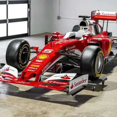Lebensgroße Replika eines Ferrari SF16-H Formel-1-Autos im Maßstab 1:1, rote Lackierung mit Startnummer 5 und Sponsorenlogos, ausgestellt in einer hellen Halle.