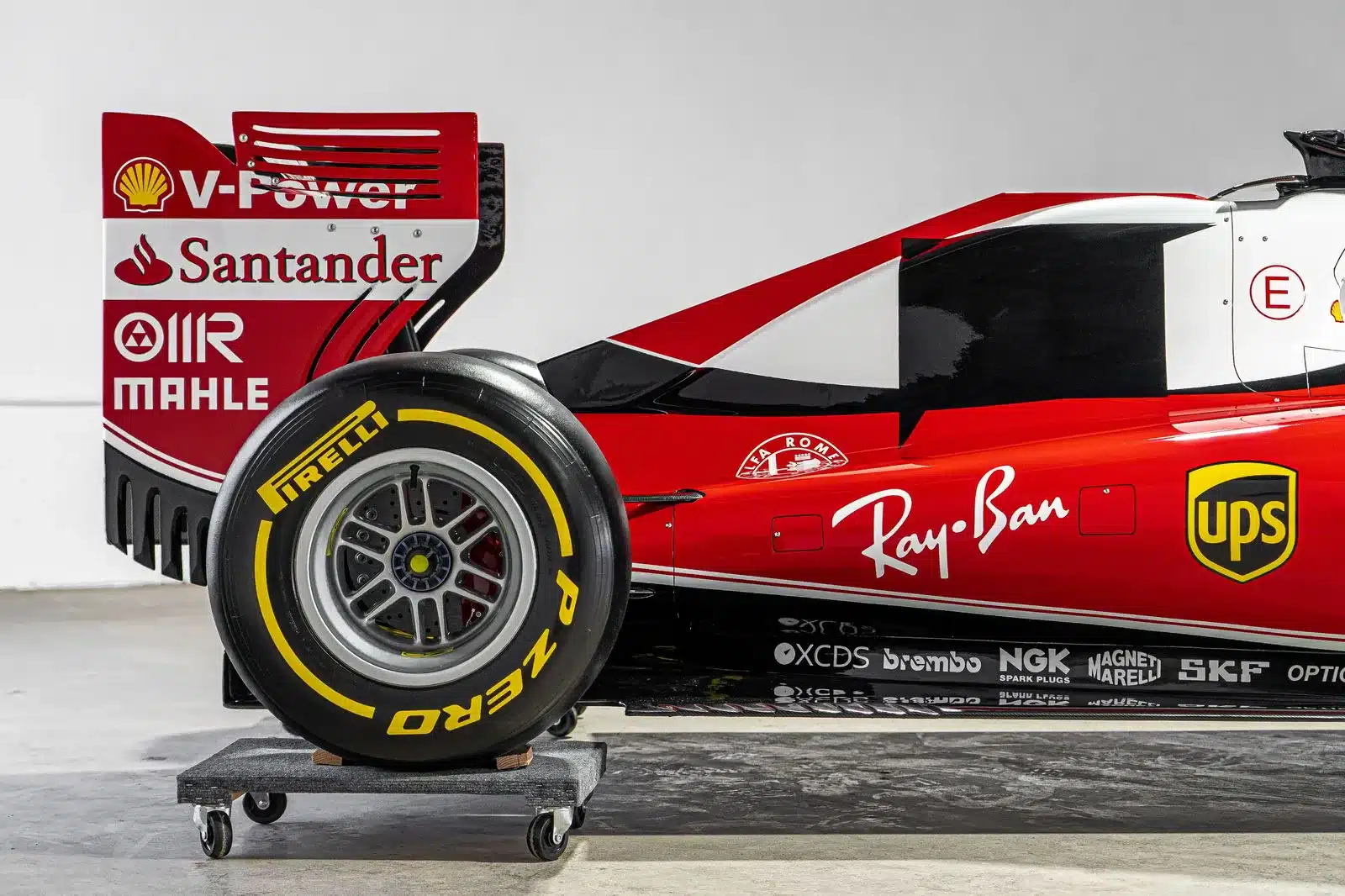 Detailfoto vom Heck und Hinterrad einer Ferrari SF16-H 1:1 Replika mit auffälligen Sponsorenaufklebern und Pirelli Bereifung.