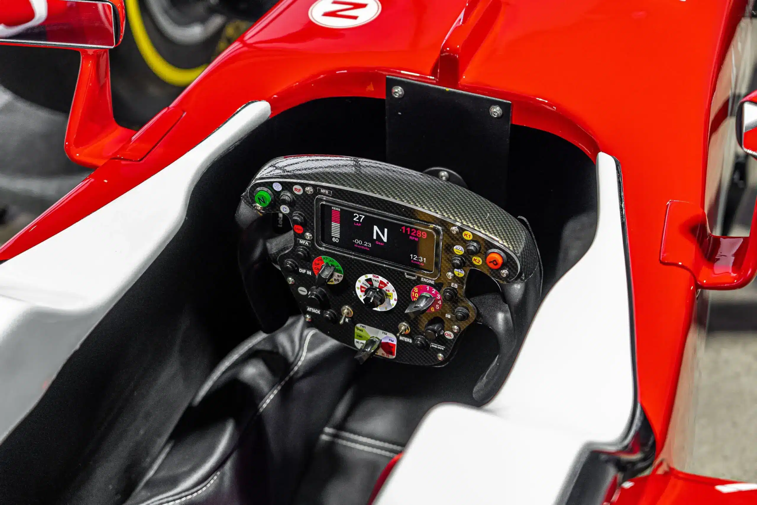 Nahaufnahme des Cockpits mit F1-Lenkrad einer lebensgroßen Ferrari SF16-H Replika, inklusive Display und Bedienelementen.