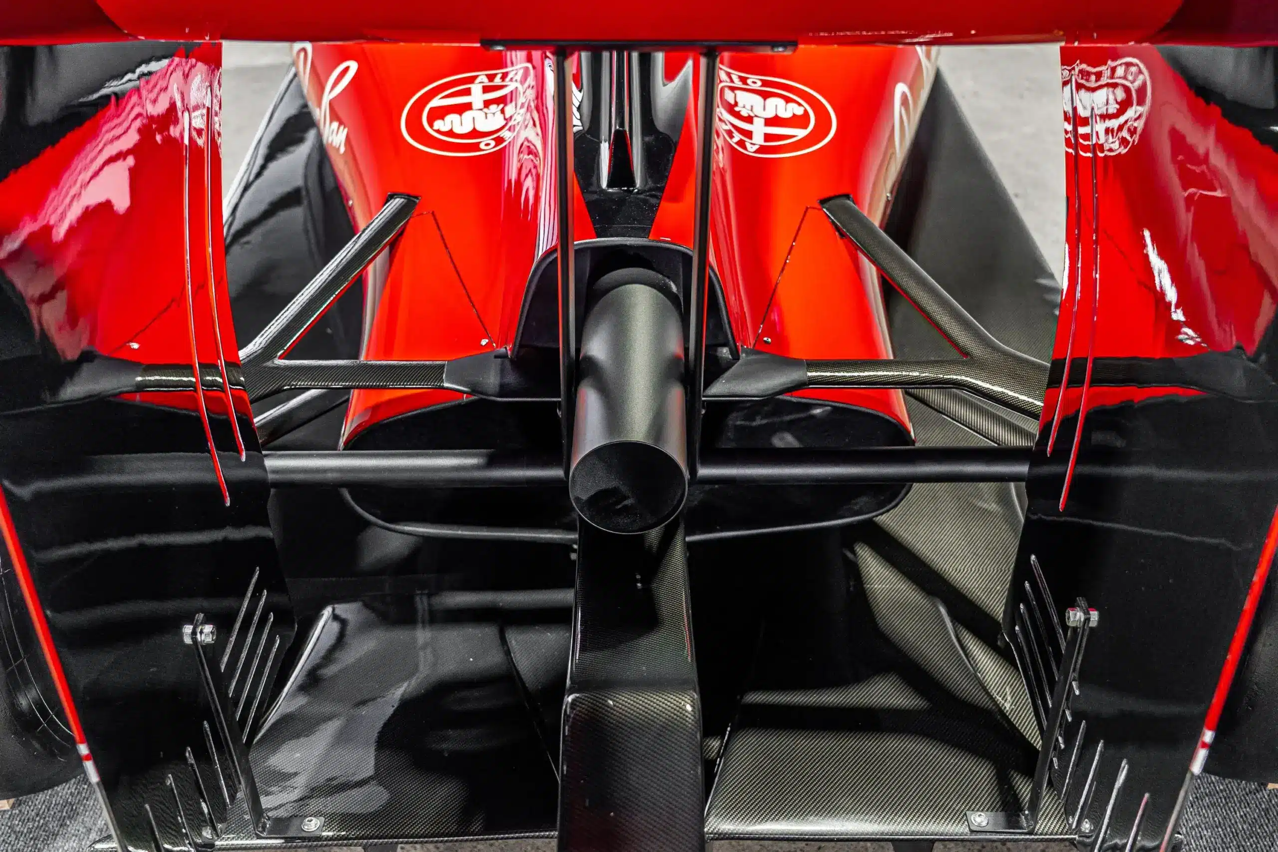 Heckflügel, Diffusor und Auspuff einer lebensgroßen Ferrari SF16-H Formel-1-Replika mit auffälliger roter Lackierung und Carbon-Details.