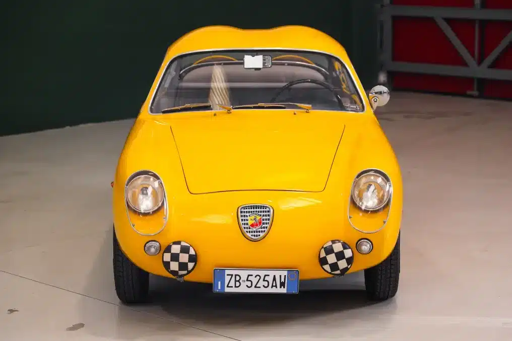 Frontalansicht eines gelben Fiat Abarth 750 Zagato von 1958 mit Double-Bubble-Dach und italienischem Kennzeichen.