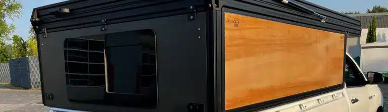 Modularer FLEXS Aufbau mit Pop-up-Dach und Seitenpaneelen auf der Ladefläche eines weißen Pickups