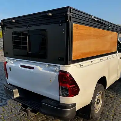 Modularer FLEXS-Aufbau aus Aluminium und Holz auf der Ladefläche eines weißen Pickups