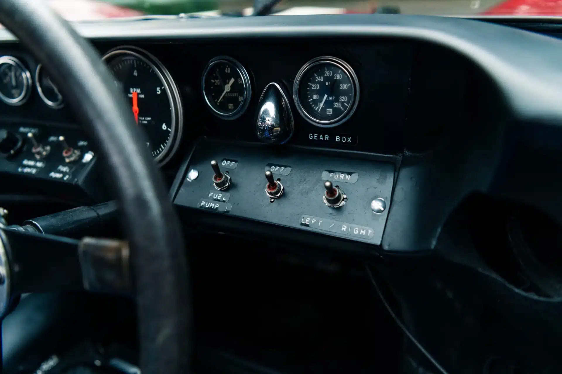Detailansicht des Cockpits und Armaturenbretts im Ford GT40 MkII XGT-3, mit Instrumenten und Schaltern.