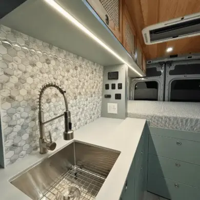 Küchenzeile mit Edelstahlspüle, Wasserhahn und danebenliegendem Stauraum im Ford Transit Bon Echo Campervan